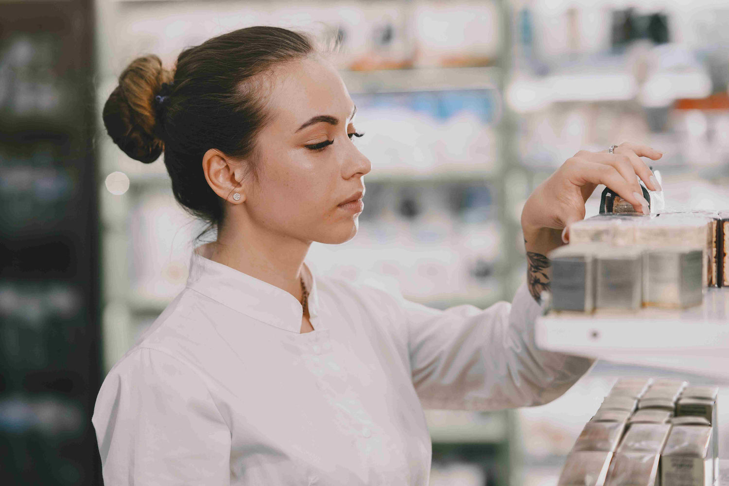 A woman in a pharmacy setting examining a skincare bottle, showcasing CelaRae's commitment to quality and innovative formulations.